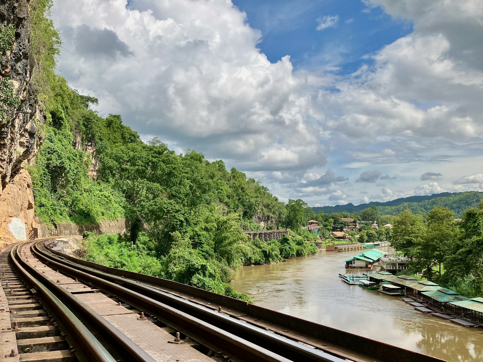 A train traveling down tracks next to a river