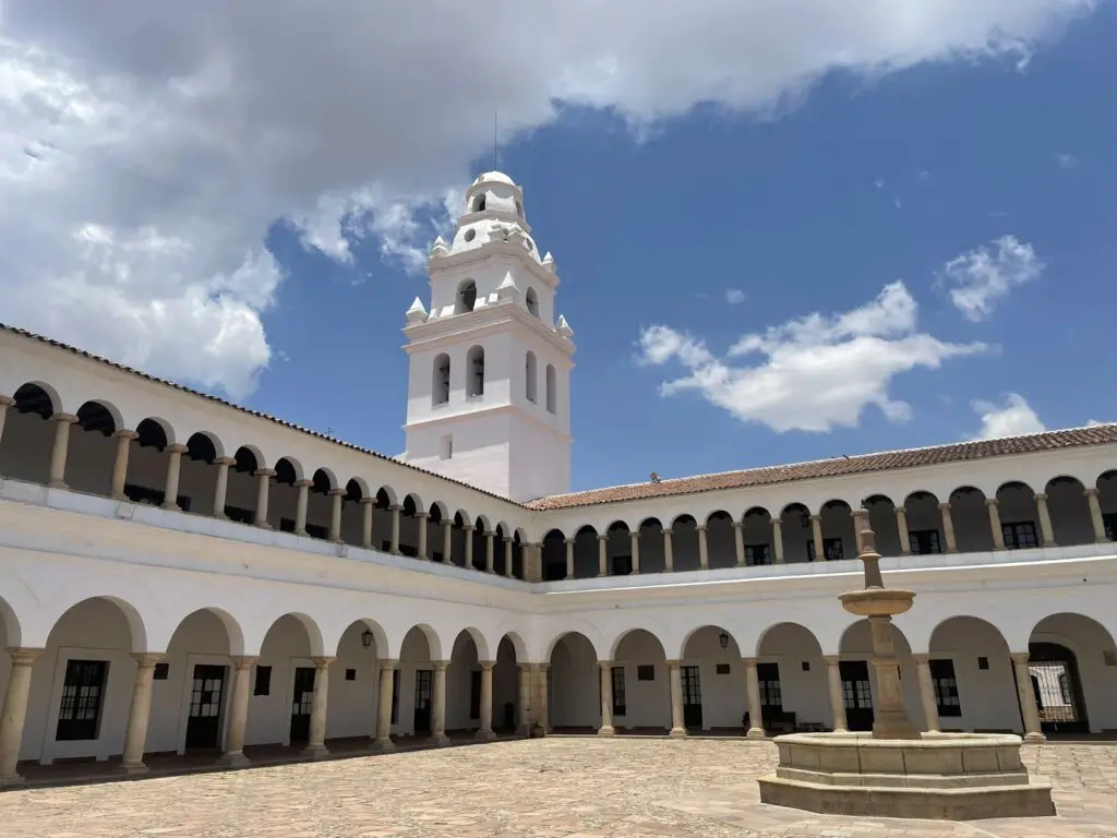 a courtyard with a clock tower in the background