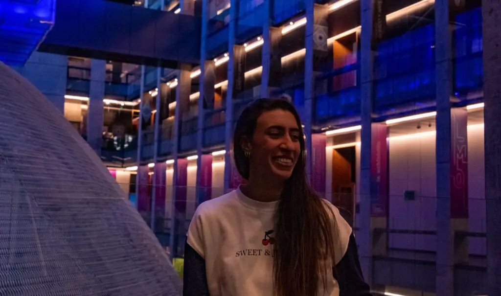 woman in white crew neck t-shirt standing near glass wall