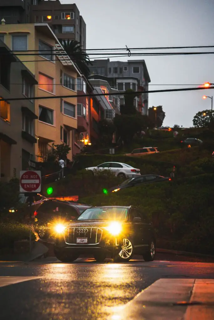 a car with its lights on driving down the street