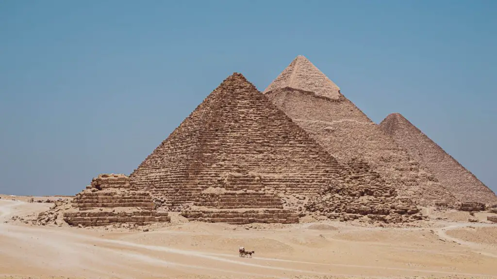 a group of pyramids in the desert with a sky background