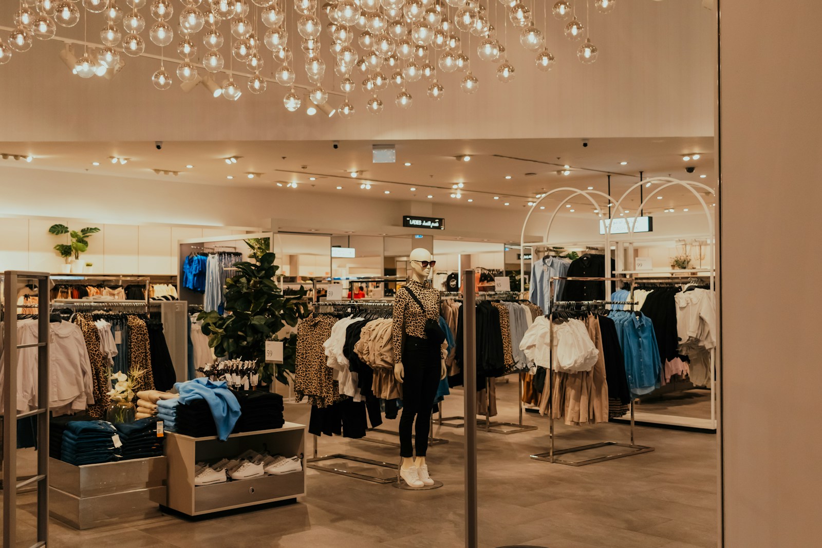 A store filled with lots of clothing and a chandelier