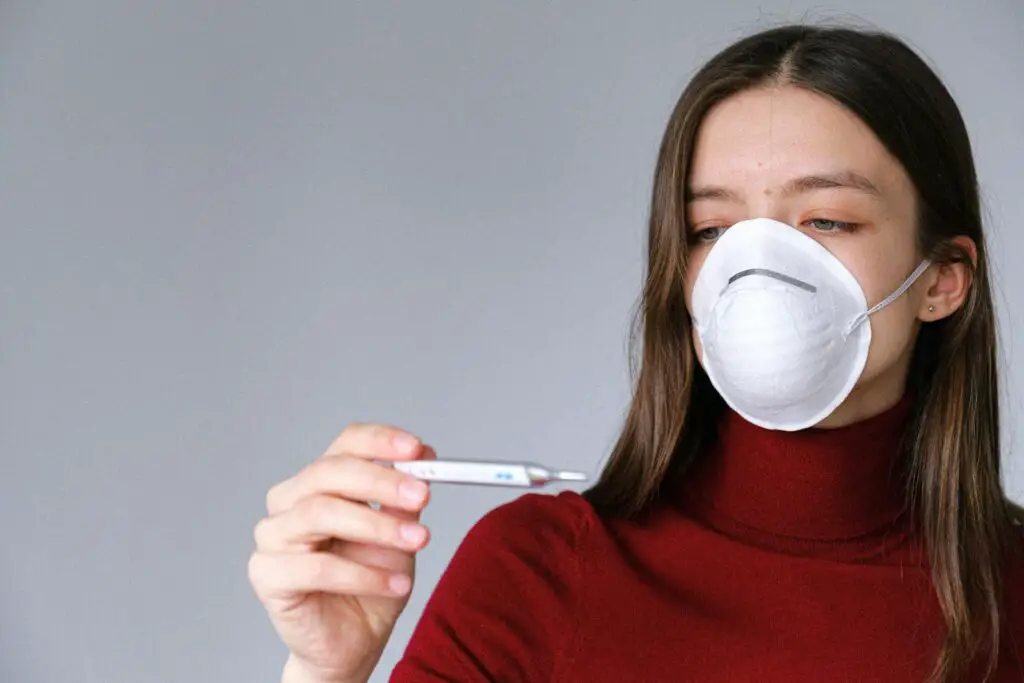 Woman in Face Mask Checking Thermometer